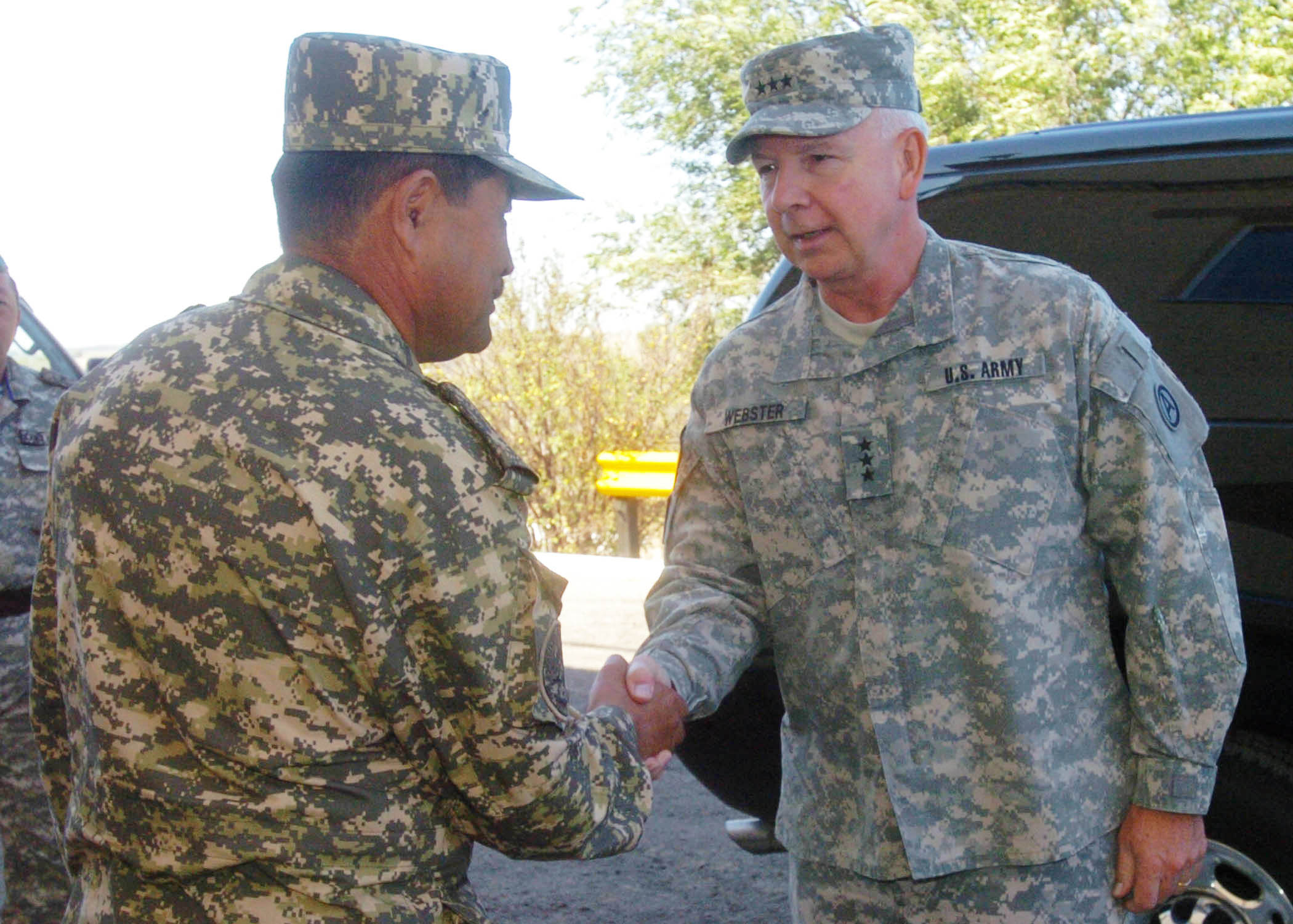 Kazakh Major General Adilbek Aldaberpenov (left) greets Lieutenant General William Glenn Webster of the United States Army, 2009.