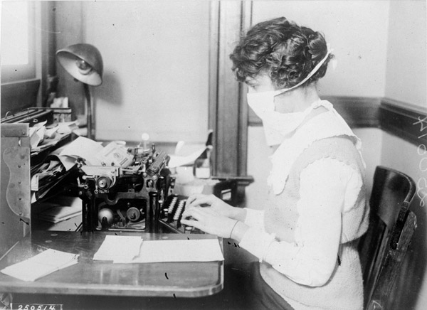 Gauze masks like the one this secretary is wearing were commonly distributed as an anti-influenza public health measure.