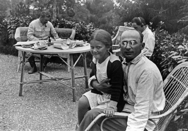 Lavrenti Beria sitting with Stalin’s young daughter, Svetlana. Stalin is in the background.