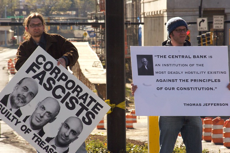 Protestors in Charlotte, North Carolina hold signs that express opposition to the Federal Reserve System and bailouts during the 2008 Financial Crisis.