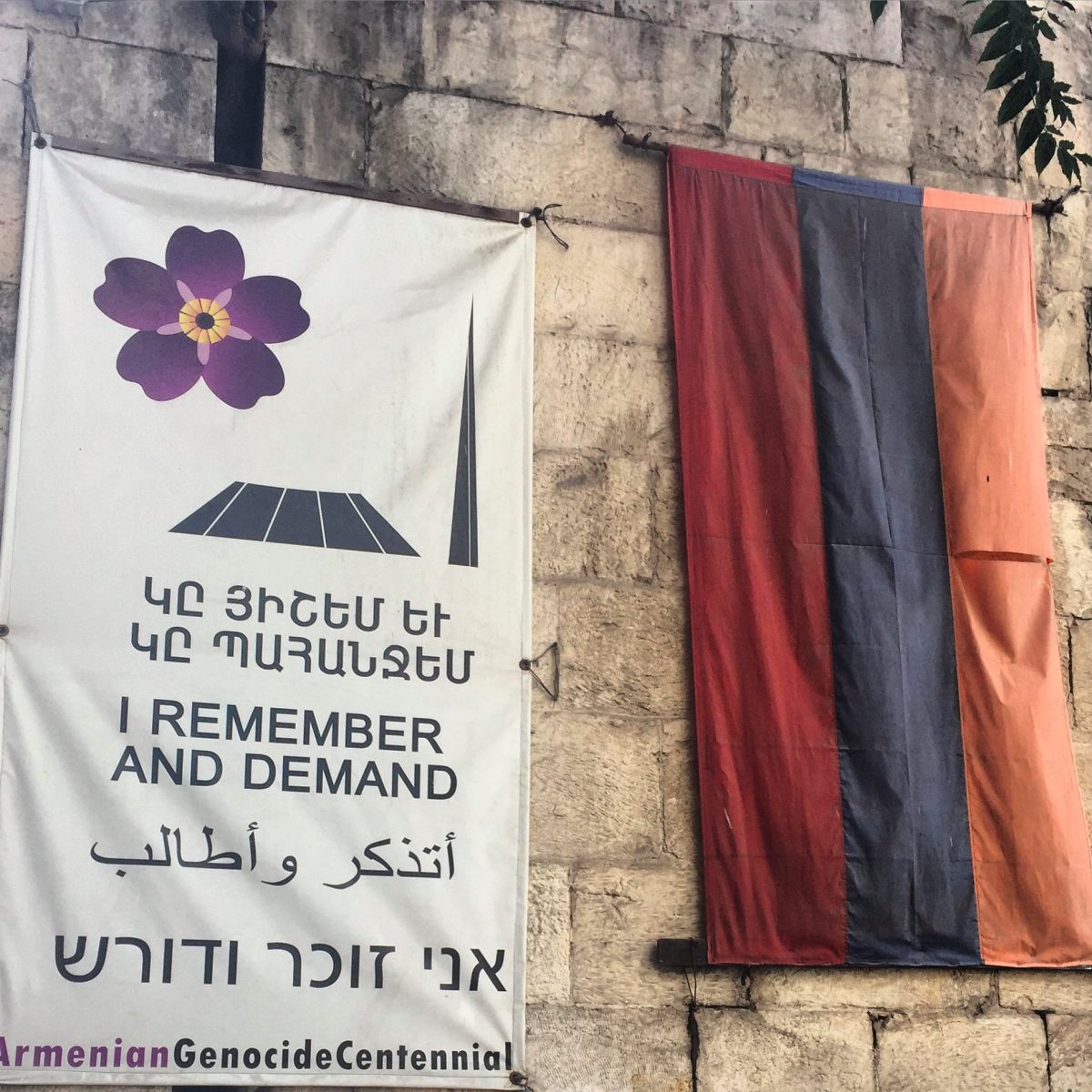 A poster and the Armenian flag hang outside a restaurant.