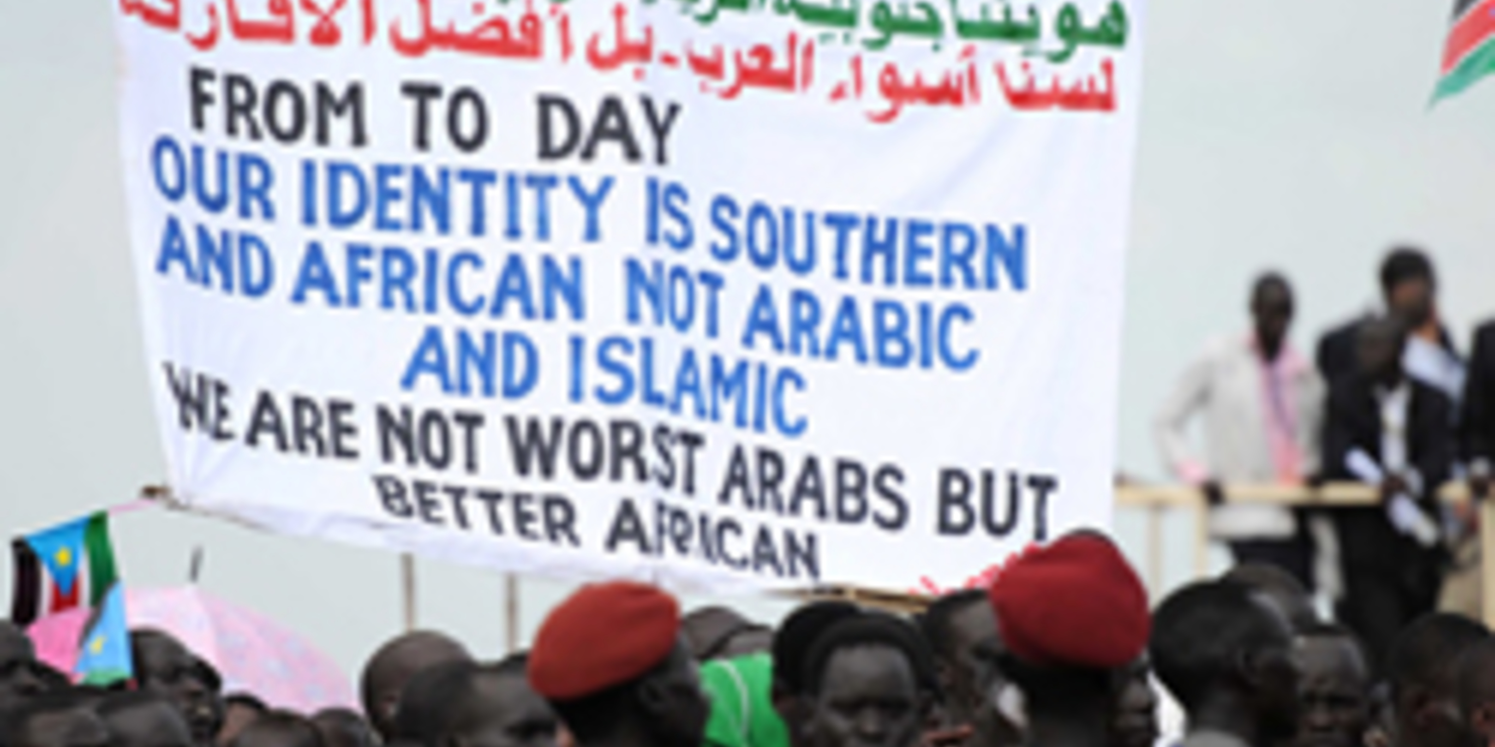 people holding sign - from today our identity is Southern and African not Arabic and Islamic