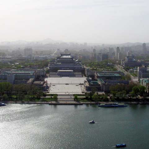 Pyongyang from the Juche Tower, facing West. Kim Il-sung Square in the Center, which is in front of the Grand People's Study House. To the right is the Ryugyong Hotel (the large triangular building)