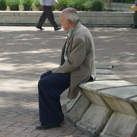 Old man sitting alone in a park.