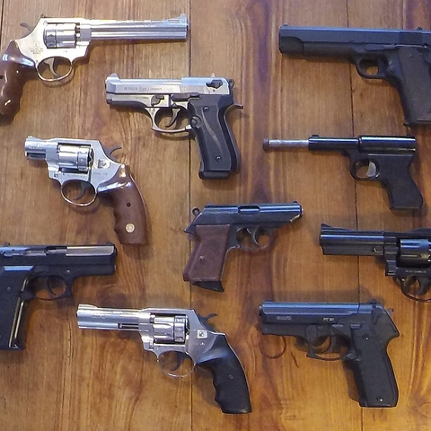 An array of non-lethal guns laid out on a table.