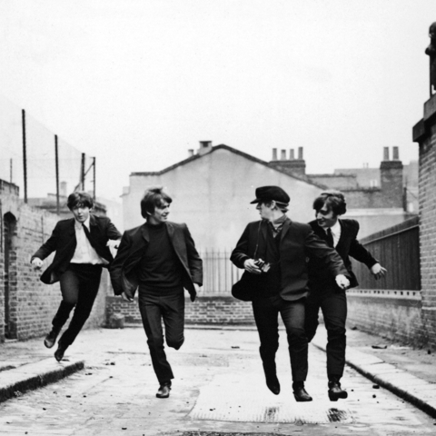 The Beatles running down a street toward the camera