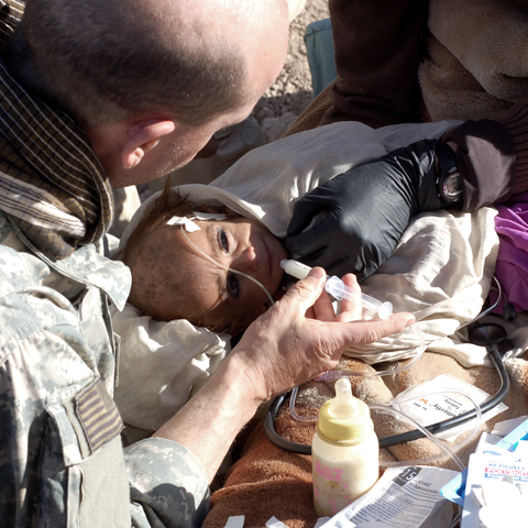 An 18 month girl, weighing 14 pounds, is treated by a US Army medical team in Paktya province, Afghanistan. December 2007