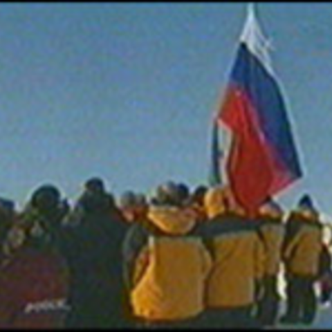 Russian explorers plant a flag in the polar ice at "North Pole-32" research station in 2003.