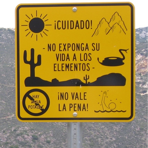 A sign near the U.S.-Mexico border warning in Spanish: "Caution! Do not expose your life to the elements. There is no potable water. It's not worth it!"