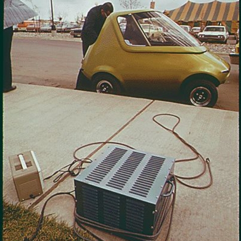 General Motors Urban Electric Car gets a battery charge from an outlet in the parking lot at the first symposium on low pollution power systems development held at the Mariott Motor Inn, Ann Arbor, Michigan, in 1973.