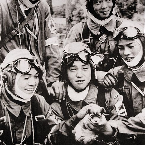 Corporal Yukio Araki holds a puppy and poses with members of his squadron.