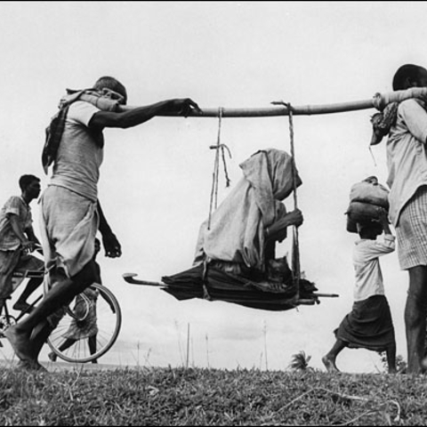 Partition refugees walking to Pakistan carrying an elderly woman.