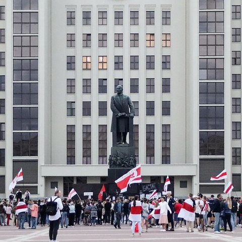 Protestors in Minsk gather around a statue of Lenin.