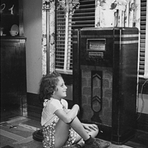 A child listens to the radio during its heyday before television.