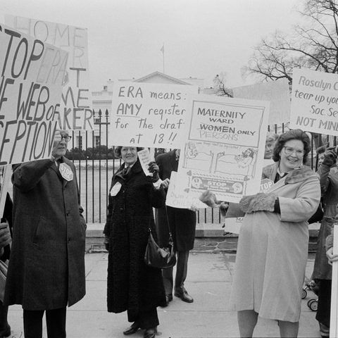 Group of women protesting against the ERA with signs: "Stop the web of deception," "ERA means Amy register for the draft at 18," "Maternity ward - persons only" 