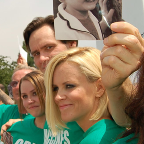 Actors Jenny McCarthy and Jim Carrey holding a photo of McCarthy’s autistic son.