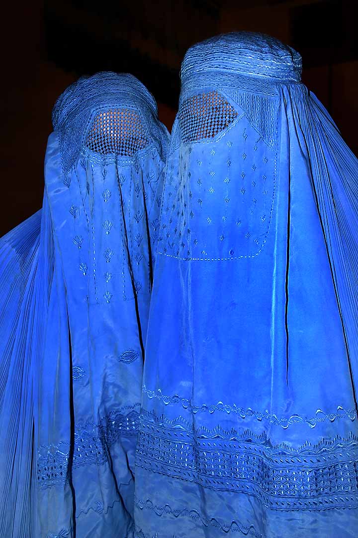 Two Afghan women dressed in bright blue burqas. Today the burqa stands as a symbol of the status of women in Afghanistan, but for much of the twentieth century the history of women in this war-torn country led also toward greater rights and public presence.