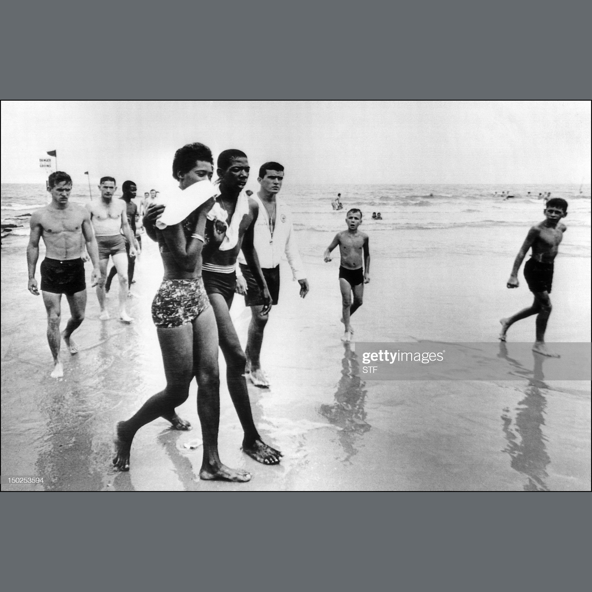 A man and his friend walk away from the water jeered and cursed by white people on the beach prior to being arrested by local police at Savannah Beach. ⁠STF/AFP via Getty Images I July 14th 1963 