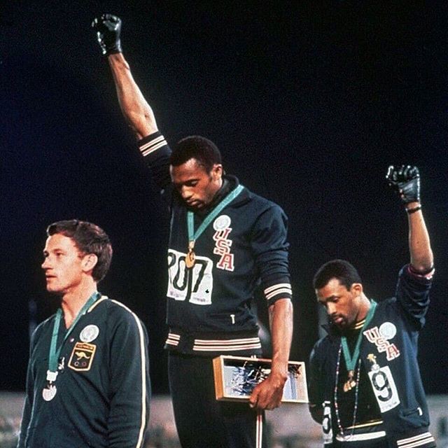 Gold medalist Tommie Smith and bronze medalist John Carlos raise their fists.