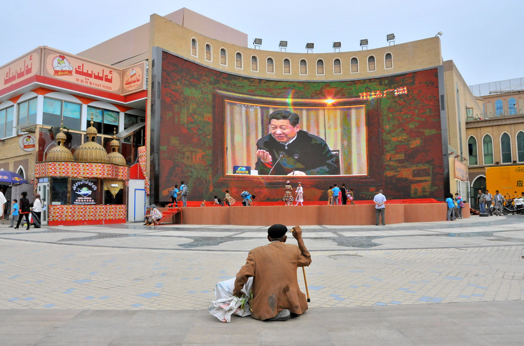 A man watches a recording of Chinese President Xi Jinping outside the Etigar Mosque in Kashgar, Xinjiang, 2015. (Image by Michael Wong)