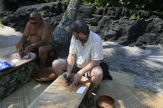 A cultural demonstrator teaches a visitor how to pound taro root into poi at the park’s annual cultural festival.