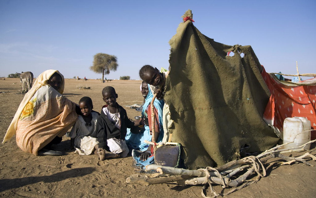 A family from Darfur construct a makeshift shelter after fleeing their home, 2010. UN Photo/Albert Gonzalez Farran