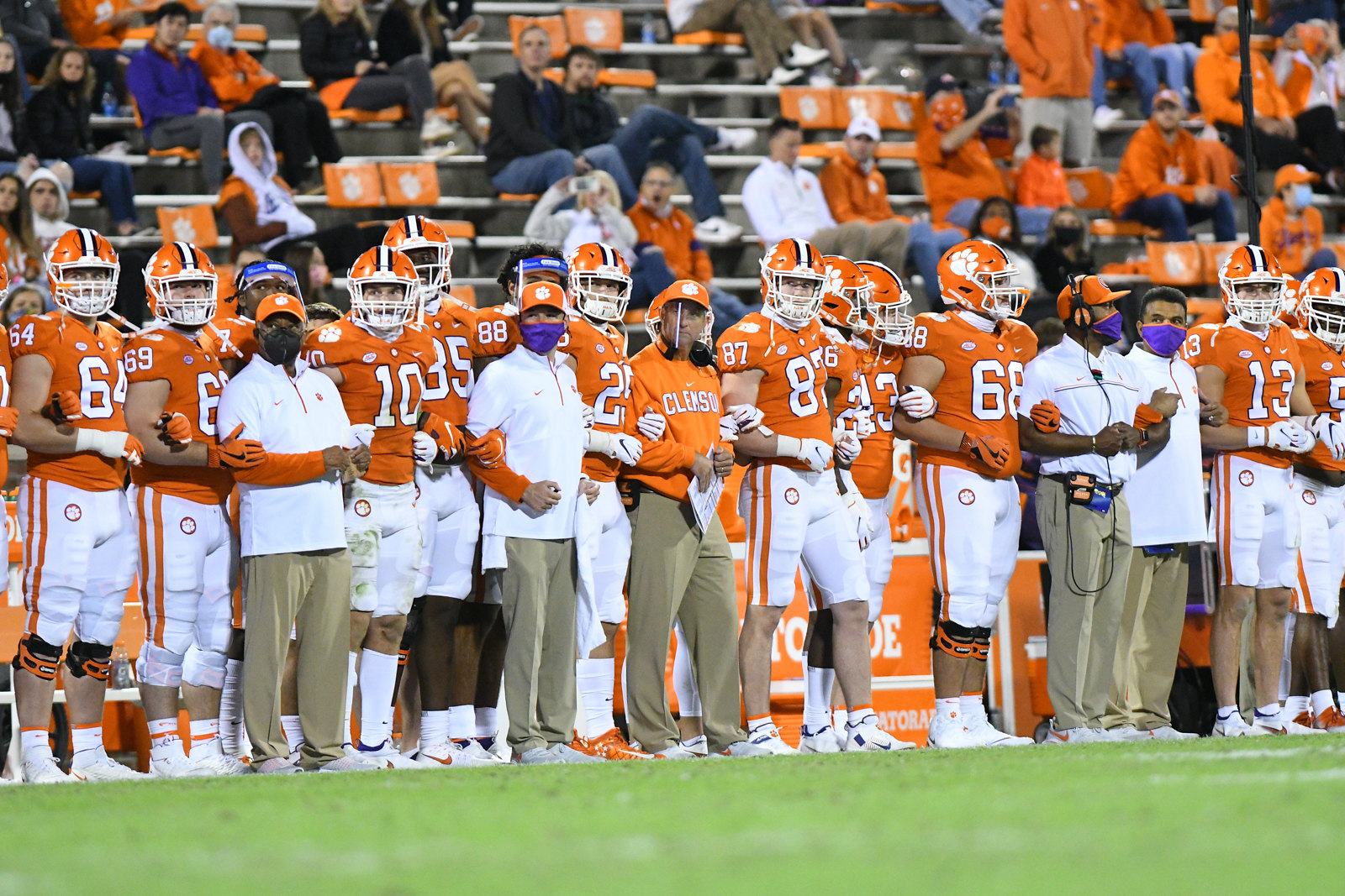 Clemson Tigers head coach, Dabo Swinney, locks arms with his team on the sideline before the start of the second quarter in the game between the Clemson Tigers and the Virginia Cavaliers on October 03, 2020.