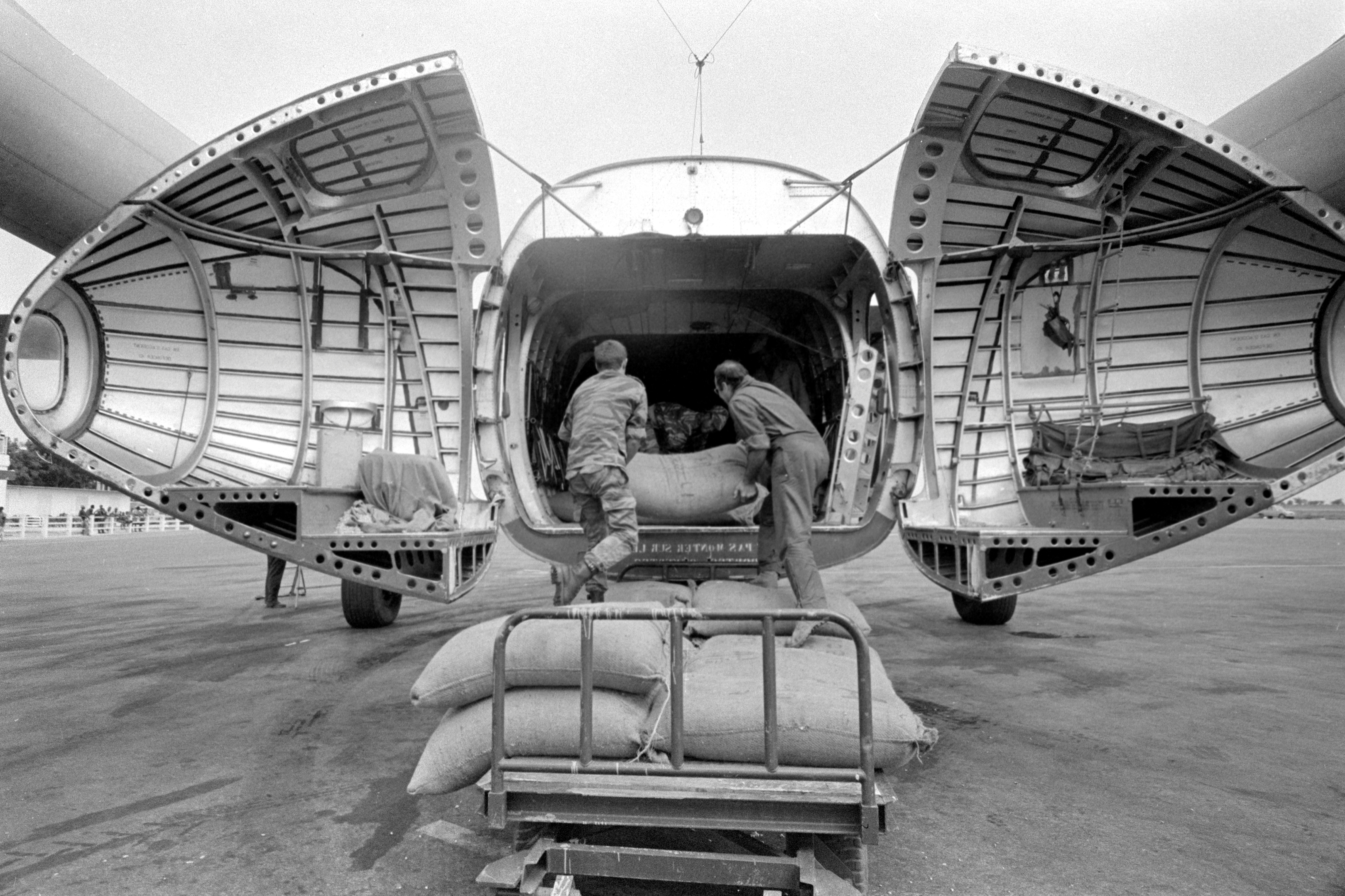 1973, Sahel, Africa - Drought in Upper Volta. Bags of sorghum donated to UN/FAO World Food Programme by U.S.A are being unloaded from a plane in Central Upper Volta. (Image courtesy of FAO)