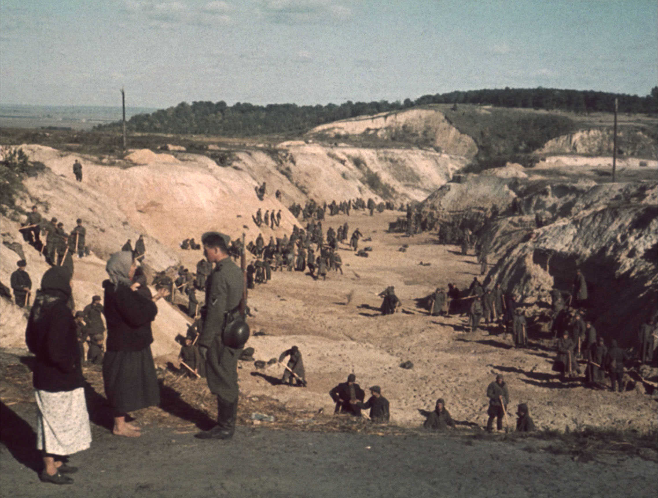 Nazi soldiers stand by while Soviet POWs cover a mass grave after the Babi Yar massacre in September, 1941, which claimed the lives of over 30,000 Ukrainian Jews.