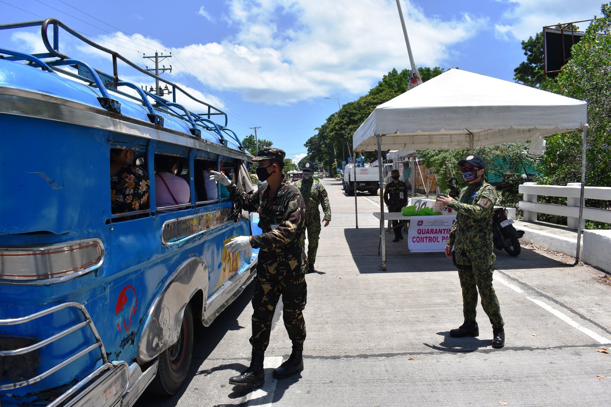 Police officers cheek a jeepney at a community quarantine checkpoint in Bohol, Philippines, 2020.