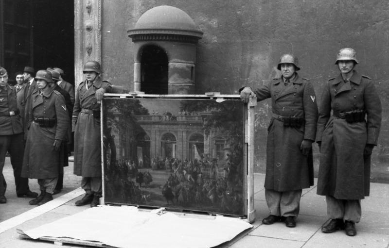German soldier pose in front of Palazzo Venezia in Rome in 1944 with a picture taken from the Biblioteca del Museo Nazionale di Napoli before the Allied forces' arrival in the city.
