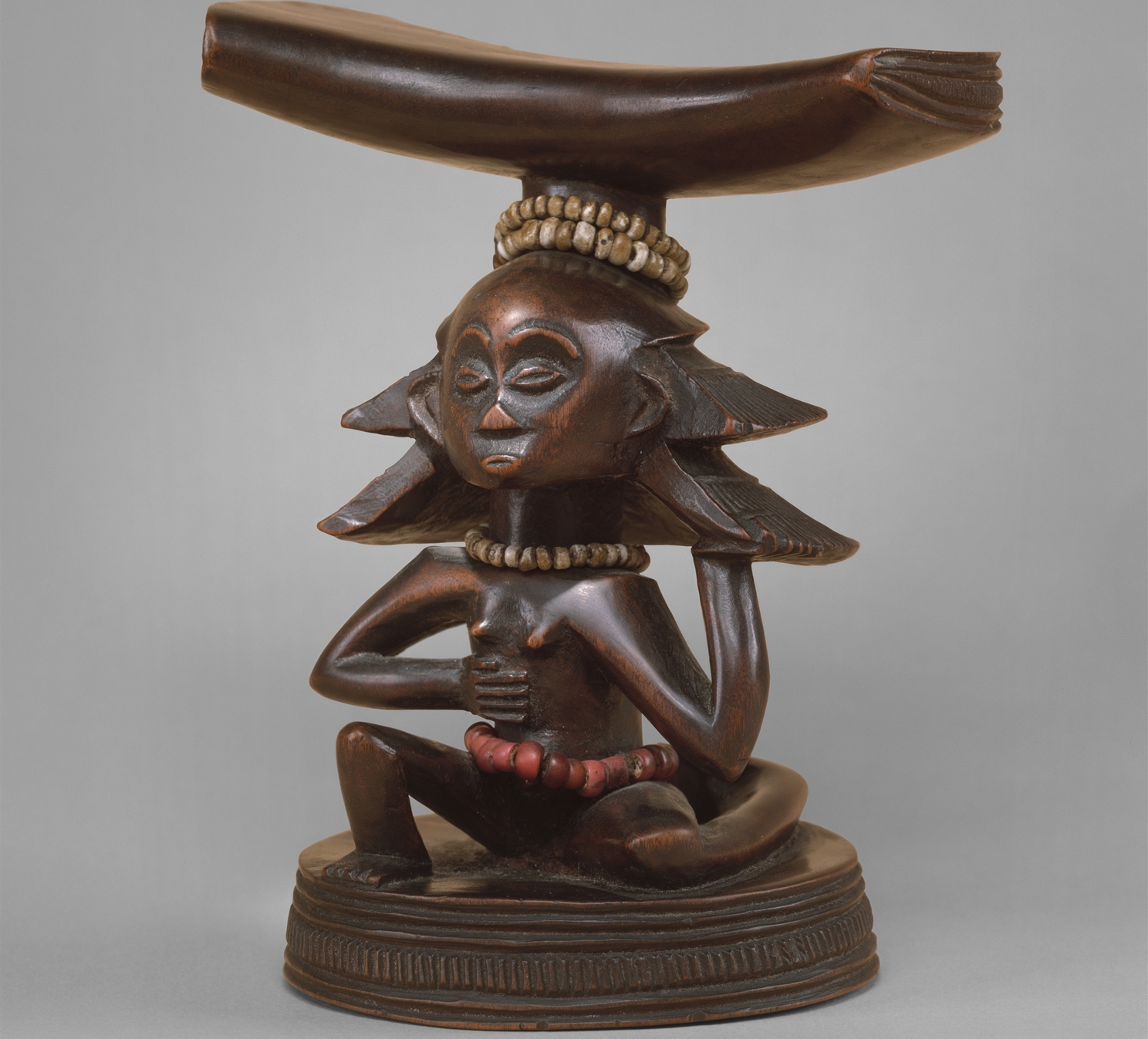 This headrest, which depicts a female caryatid figure, was sculpted an artist from the Luba people in the modern day Democratic Republic of the Congo in the nineteenth-century.