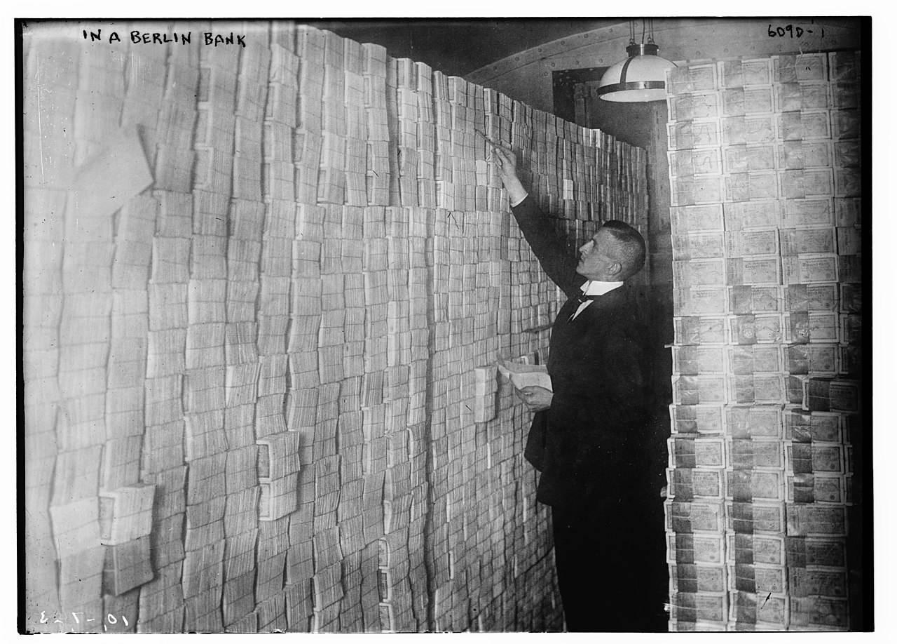A Berlin banker counting banknotes amidst hyperinflation in the Weimar Republic.