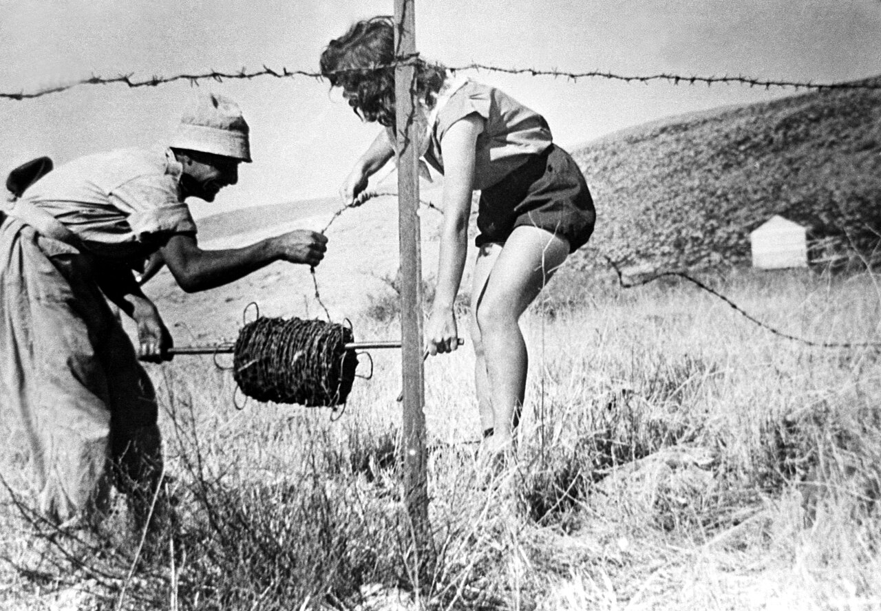 Gates, fences, moats, and other technological systems keep Palestinians and Israelis separate and unequal.  Here two Kibbutzniki build a barbed wire security fence around Kibbutz Gonen.