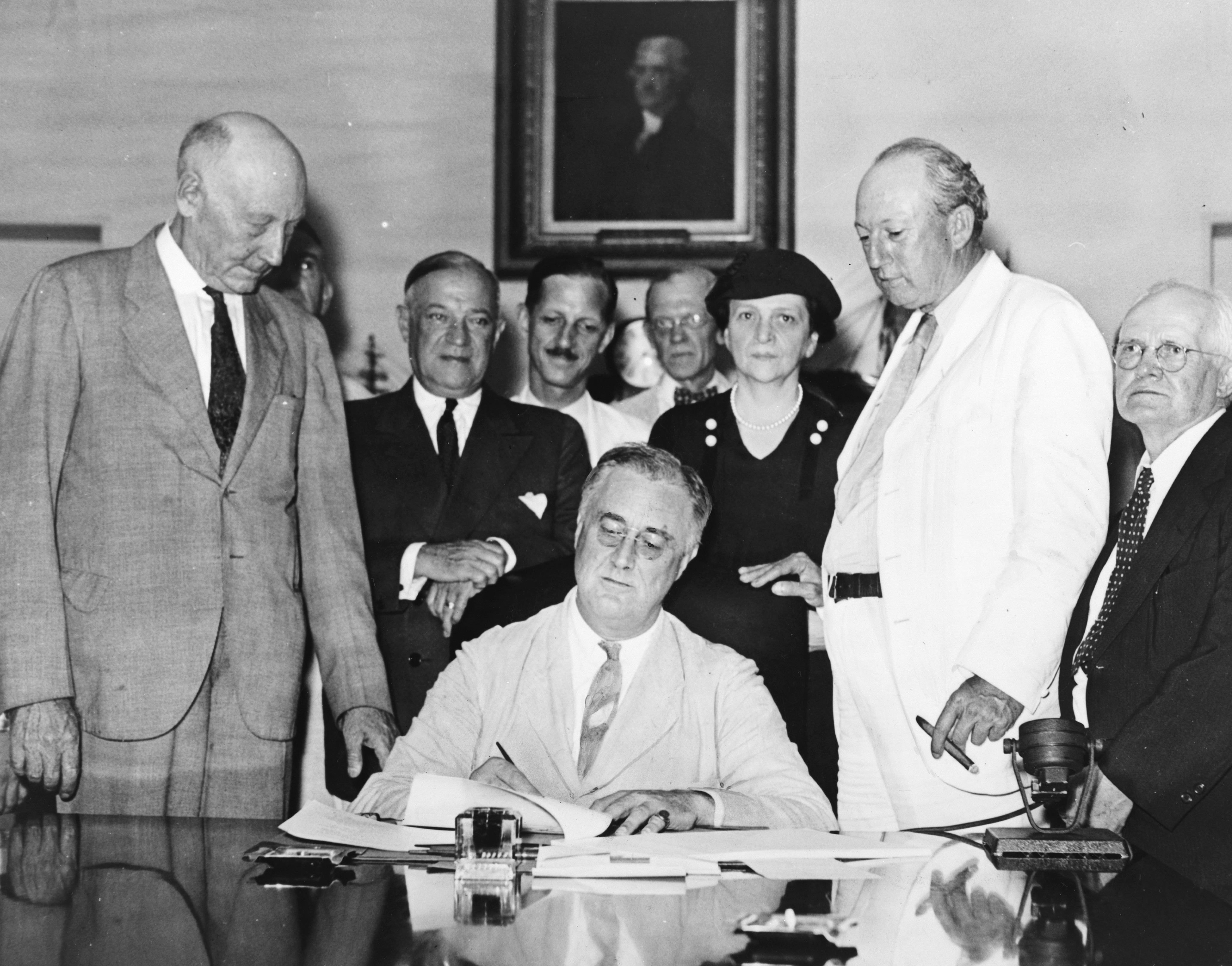 Franklin D. Roosevelt signs the Social Security Act into law, 1935.