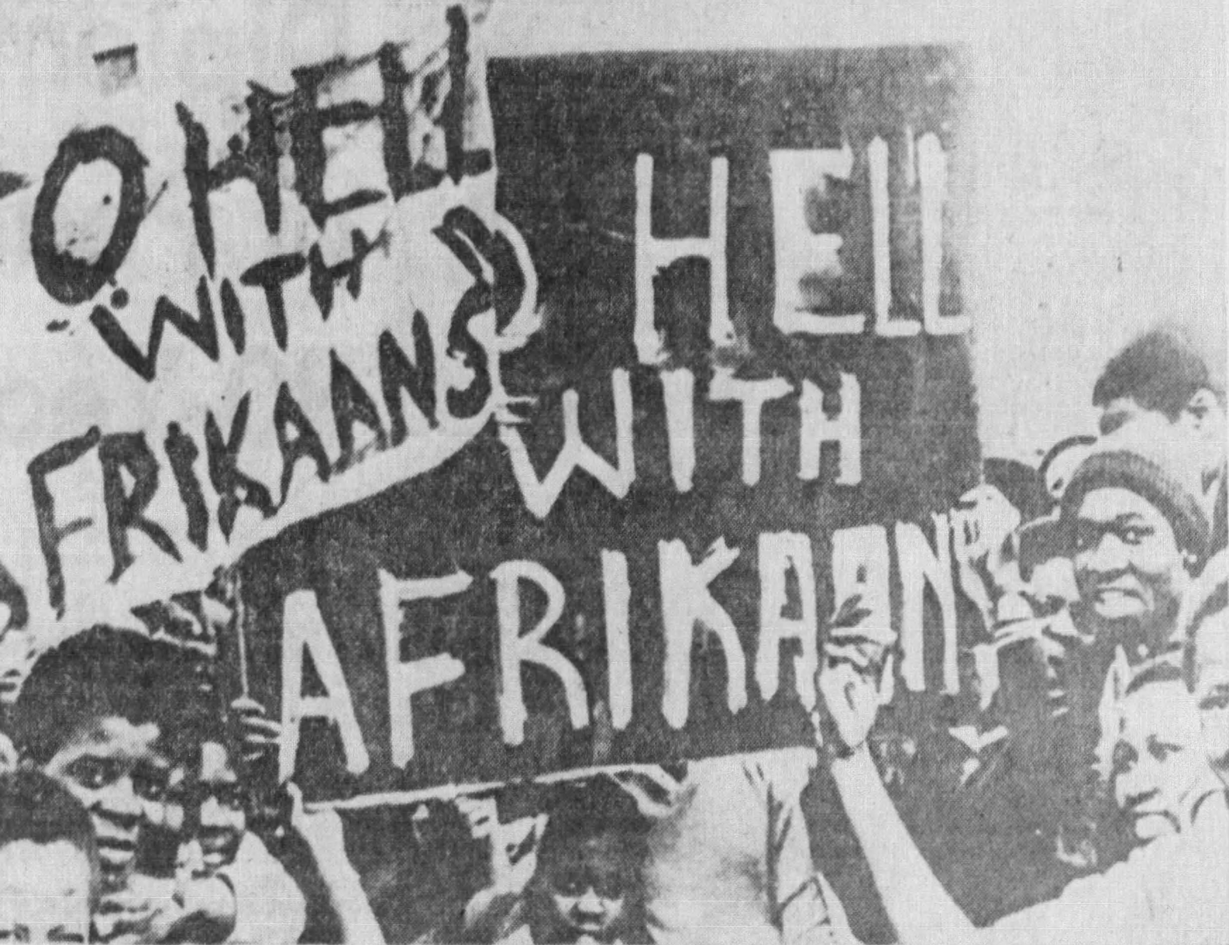 Student signs at the Soweto uprising reading "TO HELL WITH AFRIKAANS"