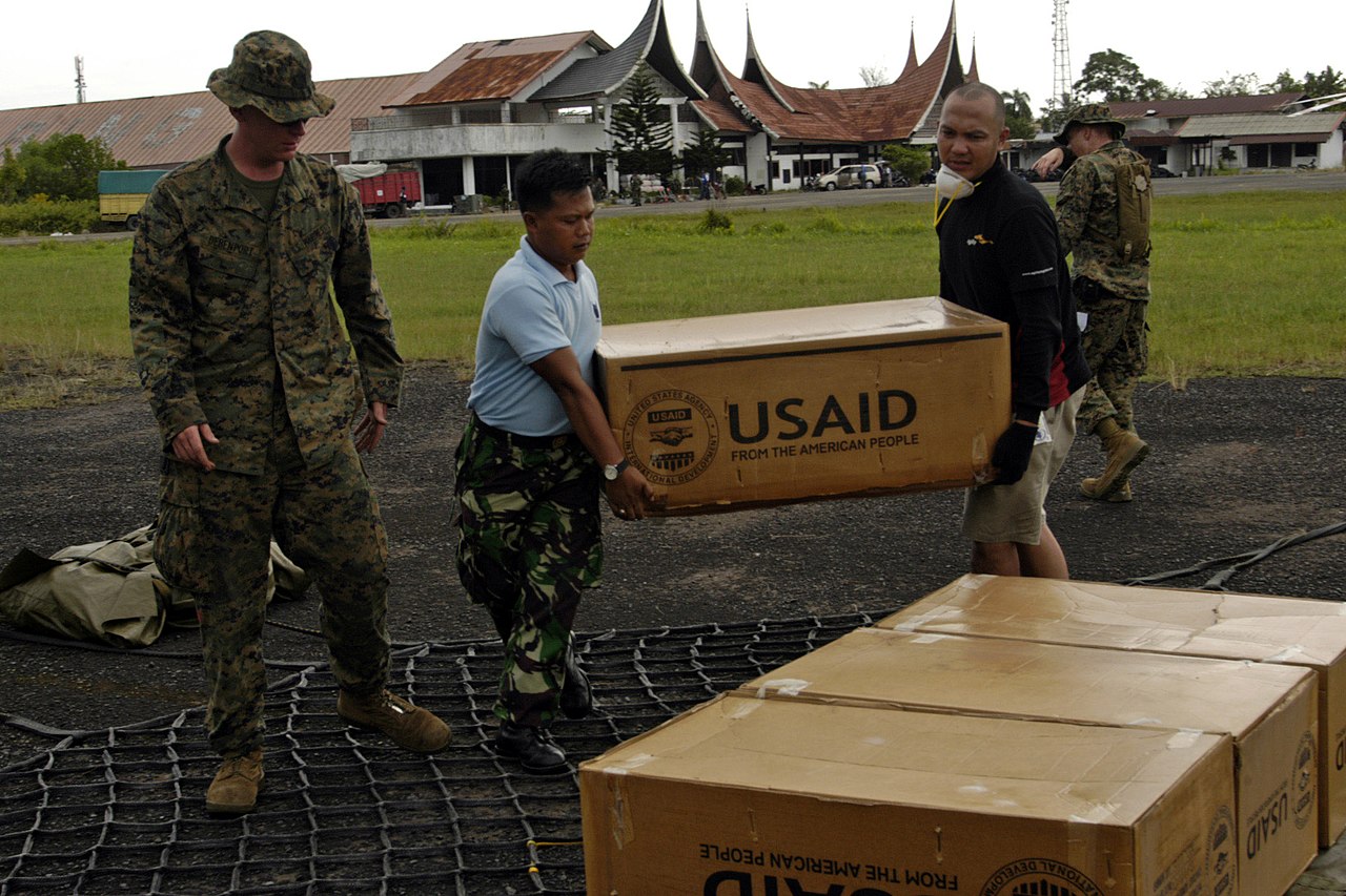 U.S. Navy Workers load a cargo net of supplies from The United States Agency for International Development (USAID), 2009.