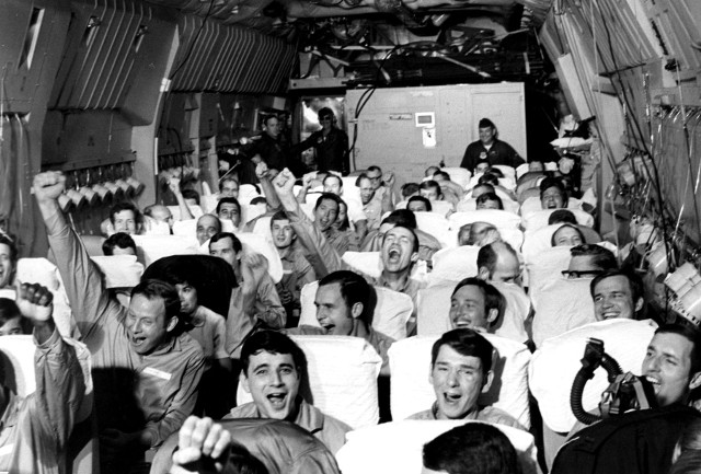 Just-released prisoners of war cheer on their flight back to the United States in 1973. Such photo-ops were always staged as politicians, especially President Richard Nixon, sought to make the most of such events.