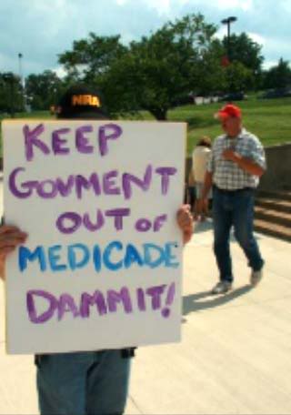A sign that reads, "Keep Govment out of Medicade Dammit!"