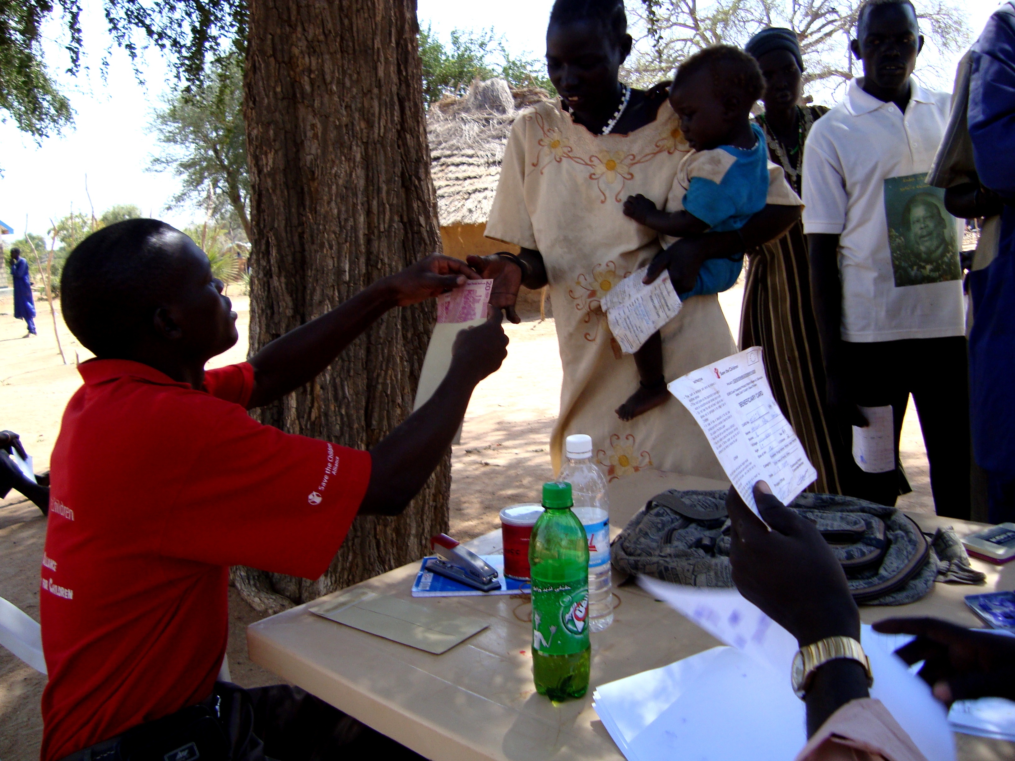 A Save the Children worker dispensing monetary aid in 2008 to families in South Sudan