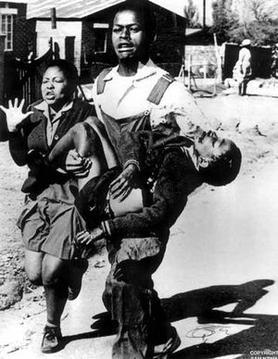 Schoolchildren fleeing after police shot the one being carried during a peaceful protest in Soweto in 1976