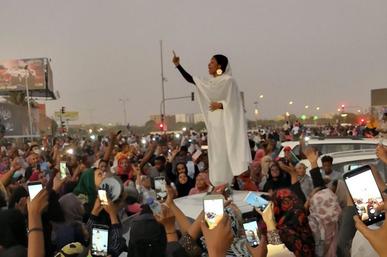A Sudanese student leading protesters in song in 2019.