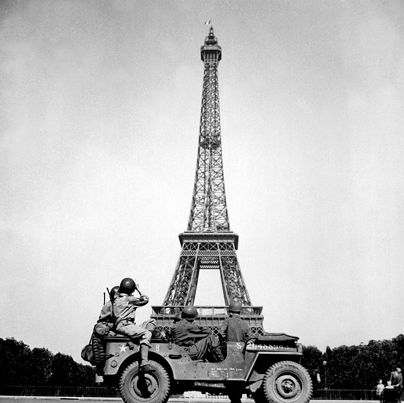 American soldiers from the U.S. 4th Infantry Division in front of the Eiffel Tower, after French firefighters raised the tricolor during the liberation of Paris, 25 August 1944.