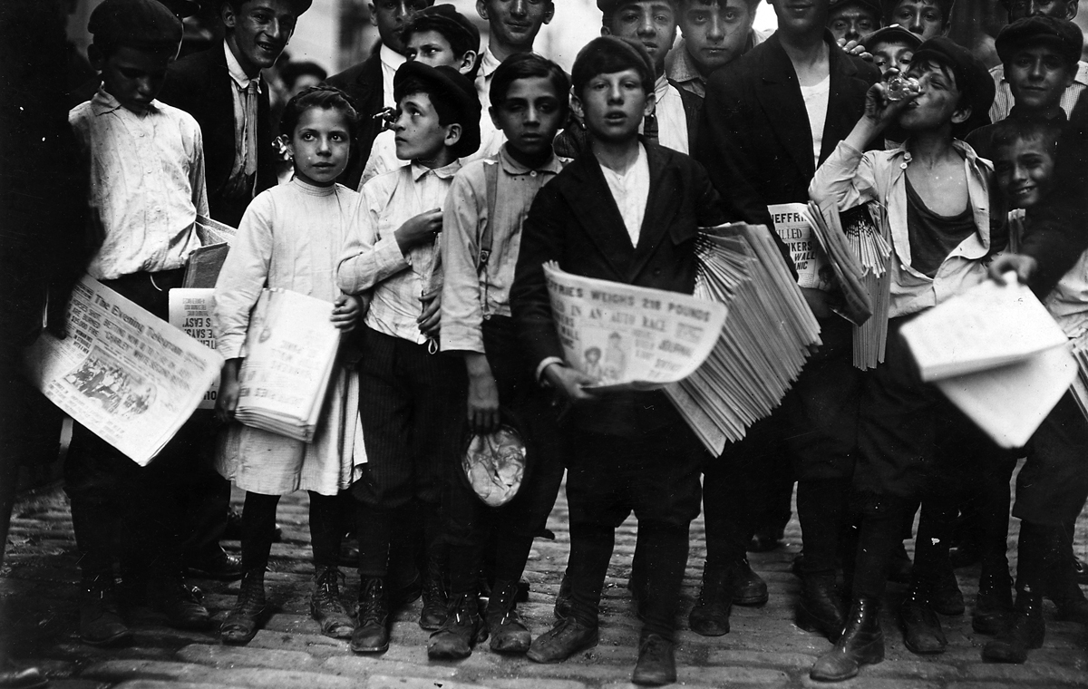 Young children picking up their newspapers to sell on the streets of New York in 1910.