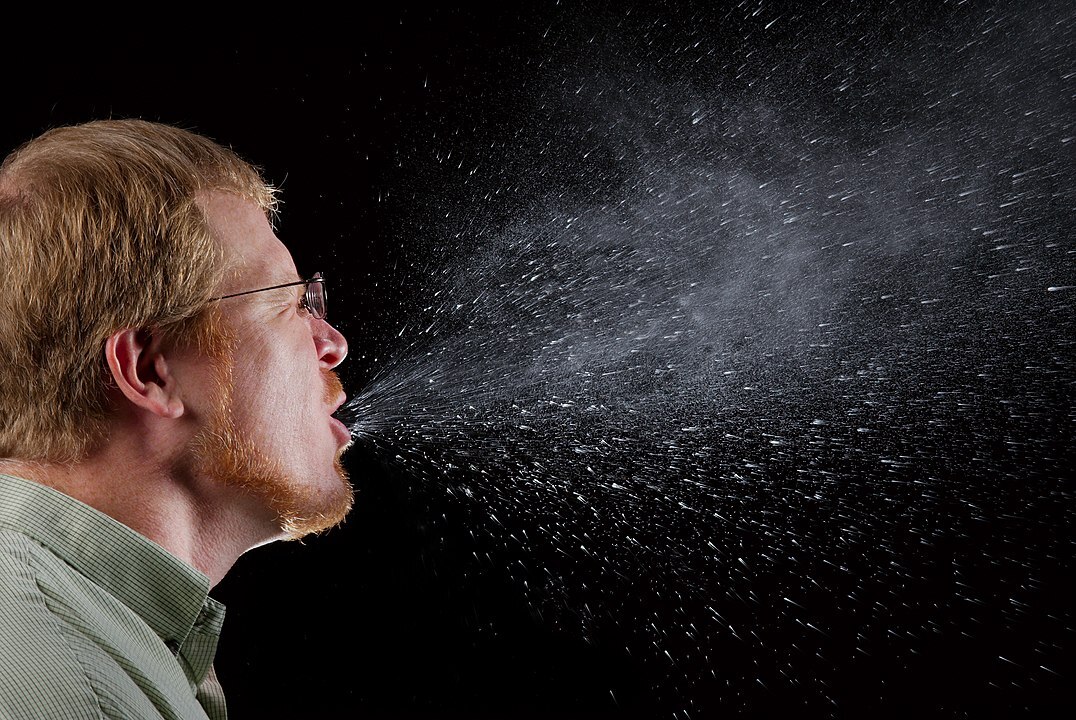 This picture of a man mid-sneeze shows how far potentially harmful droplets travel.