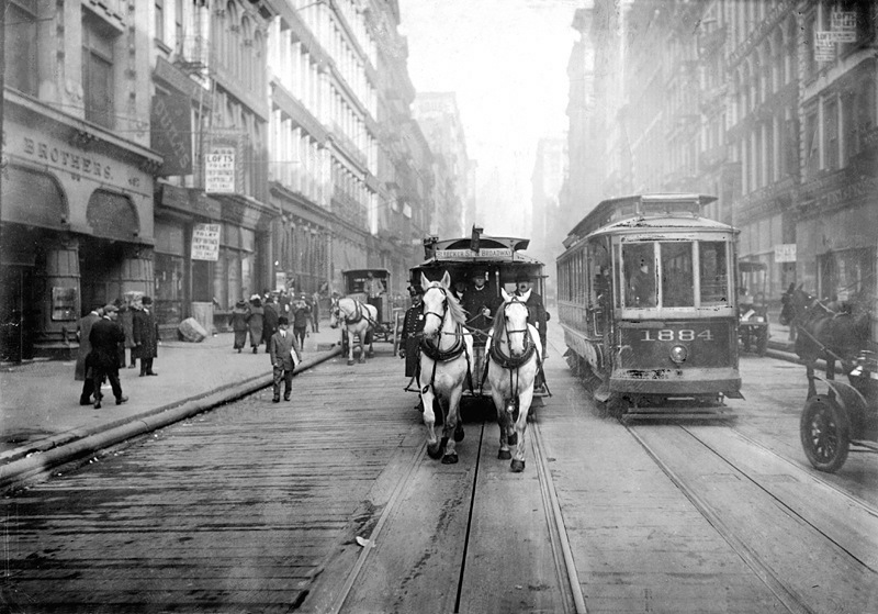 This 1917 photograph shows one of the last horse drawn carriages in New York City as it moves alongside a 'Modern Electric Car.'