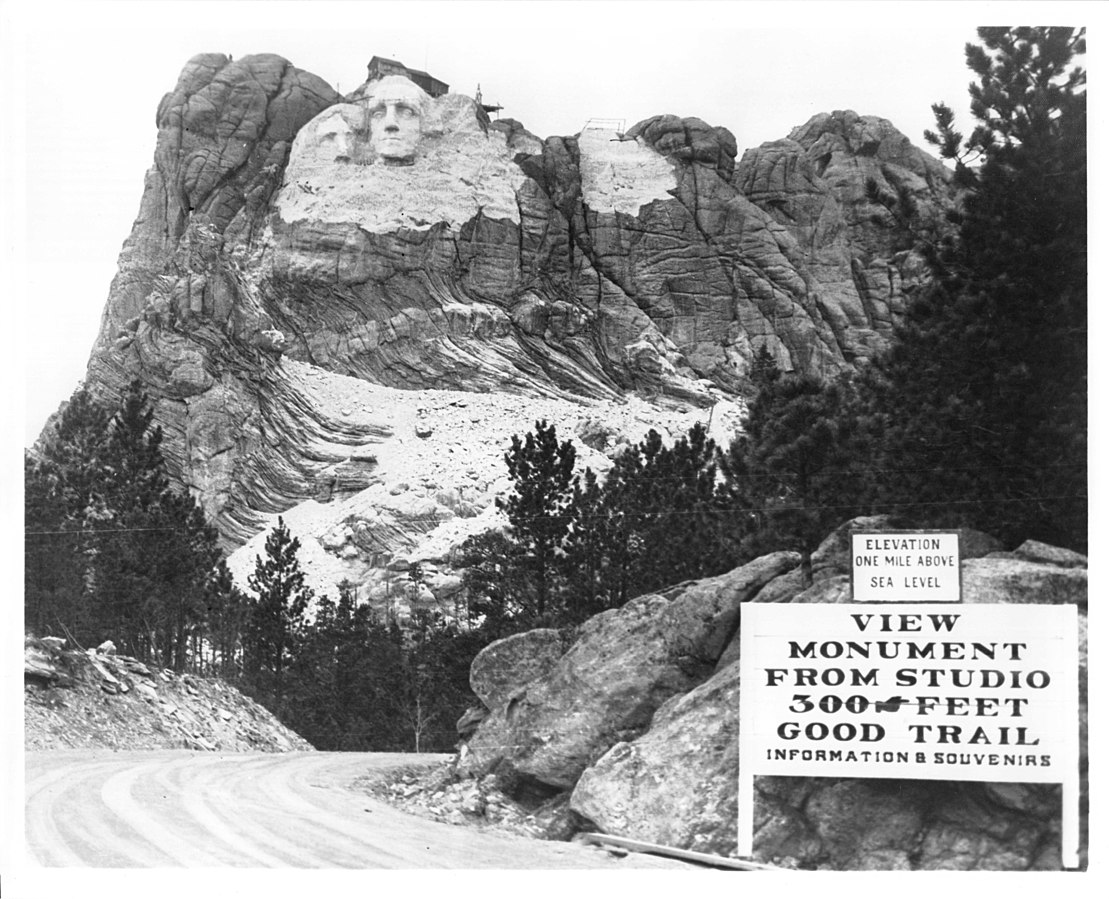 1109px-Mount_Rushmore_National_Memorial_-_welcome_sign_during_construction.jpg