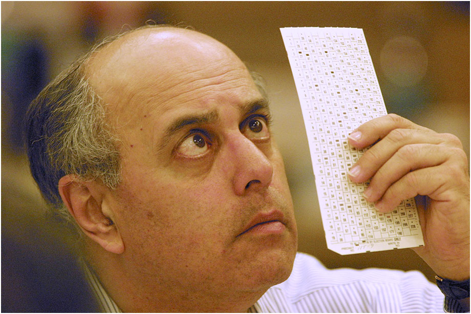 A Florida election official reviews a paper ballot during the 2000 recount.