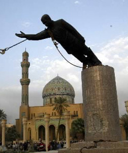 Iraqis, with the help of U.S. troops, topple a monument to Saddam Hussein.