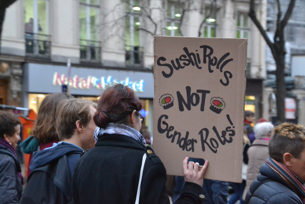 A protester’s sign mocks the notion of prescribed gender roles.